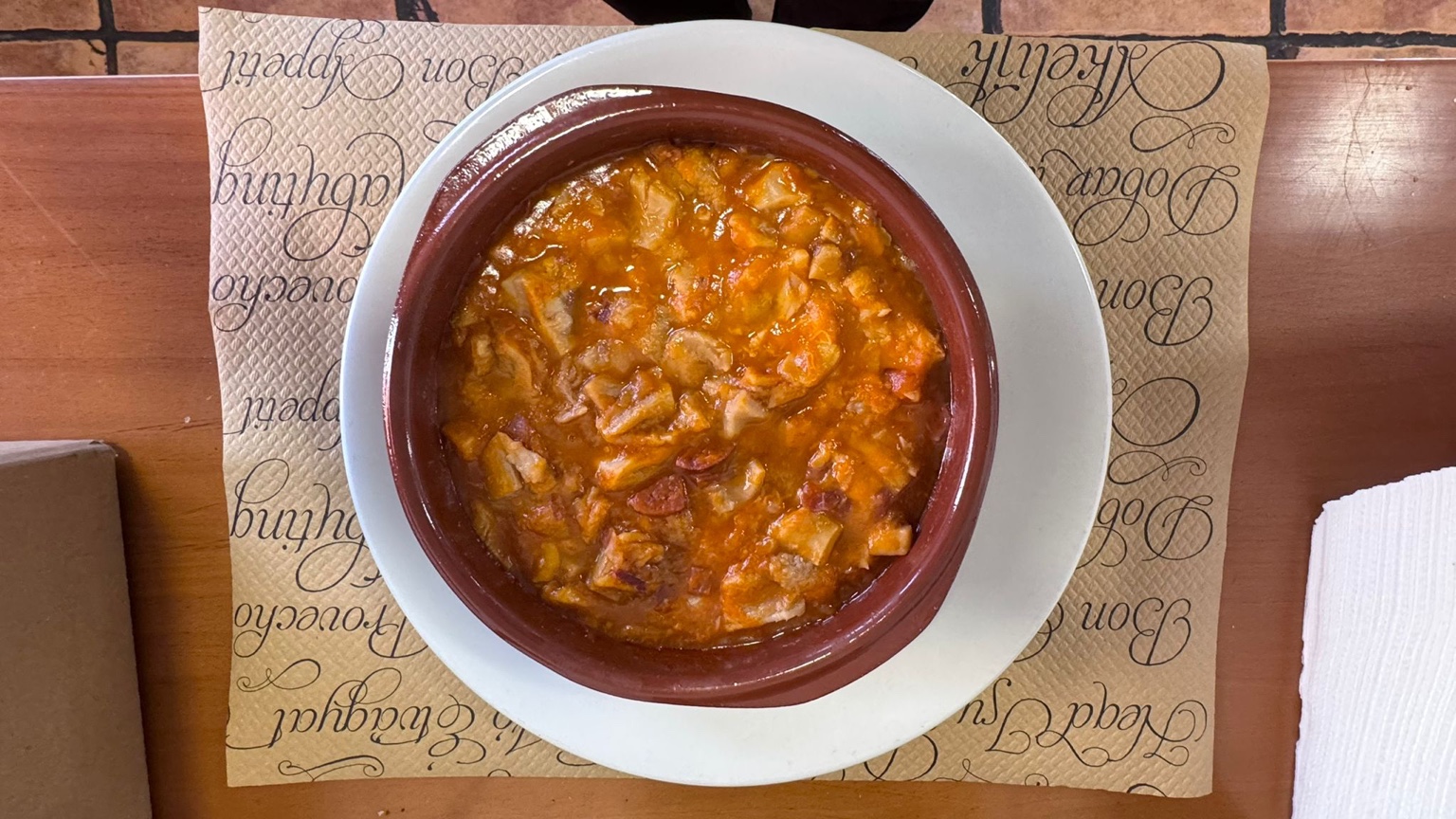 Cazuelica en salsa servida en plato de barro
